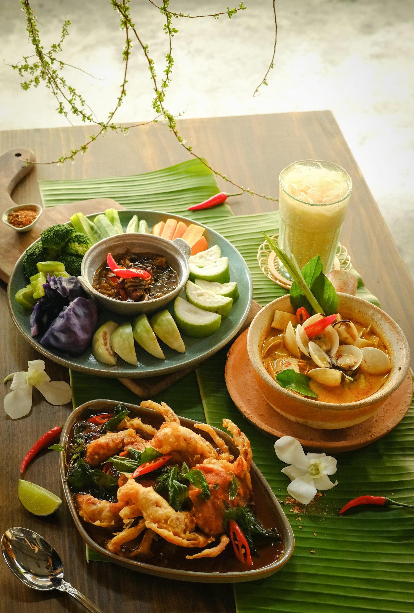 Gedeckter Tisch mit kambodschanischen Gerichten, frischem Gemüse und Dips